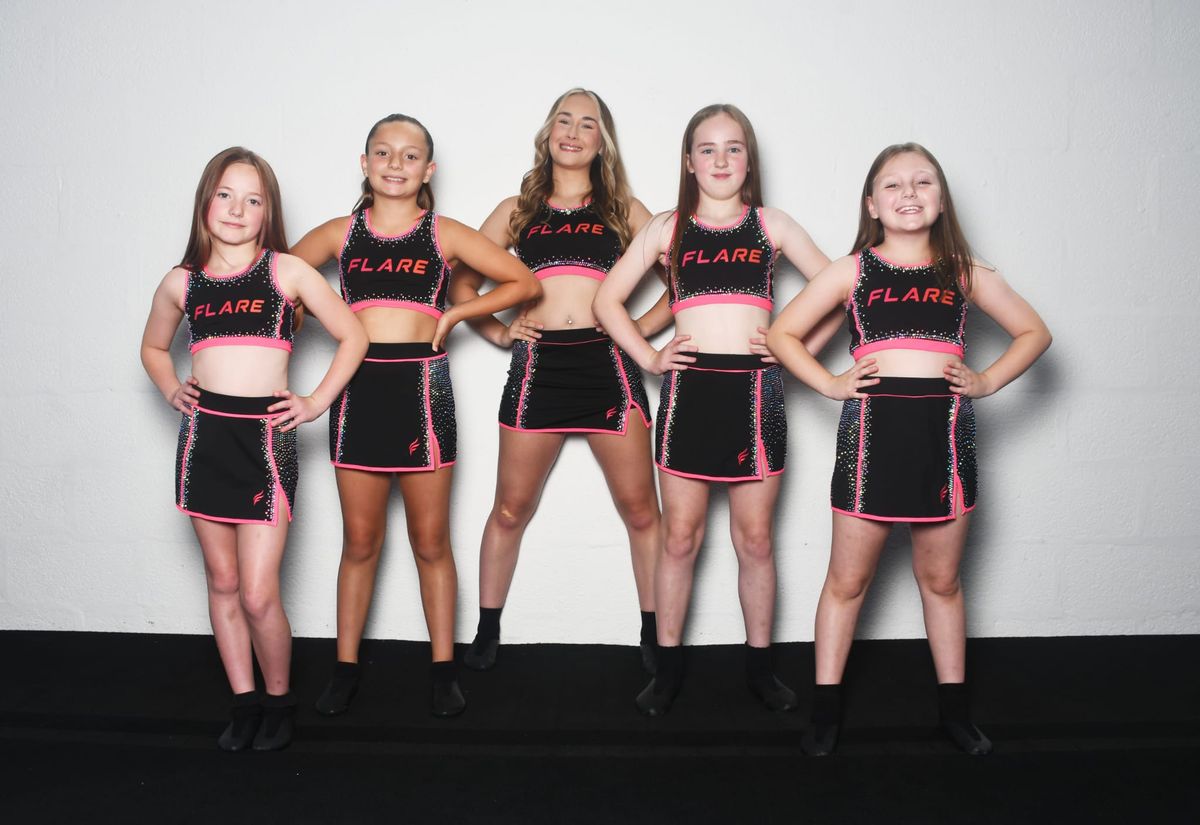 Group of five Flare Athletics UK athletes lined up in the black-and-pink rhinestone crop top and skort set during The Burn campaign shoot